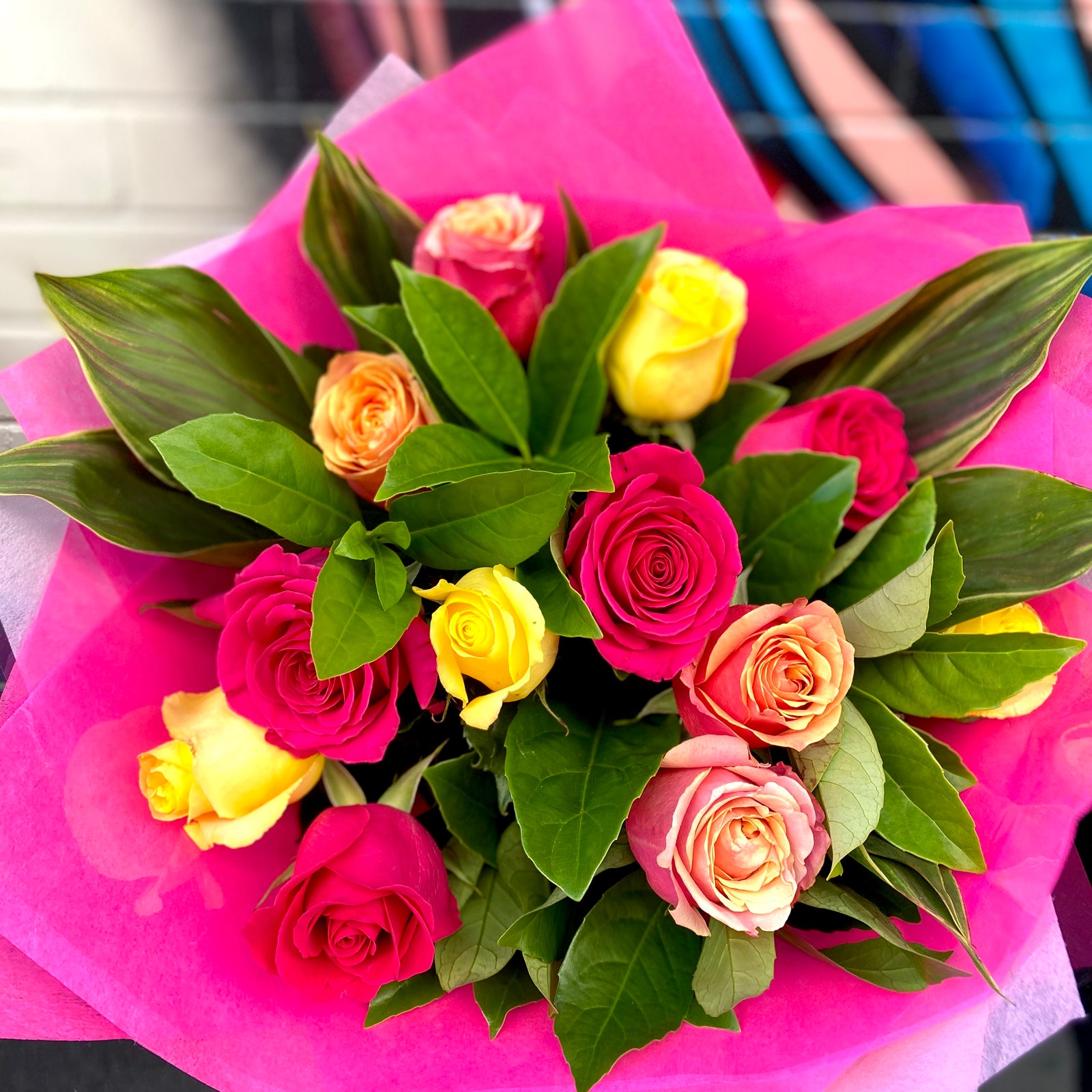 Bouquet of colorful roses with pink paper wrap on a white background